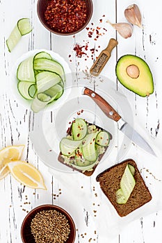 Holewheat toast with avocado guacamole and cucumber slices. Breakfast with spicy avocado sandwiches on whole grain bread.