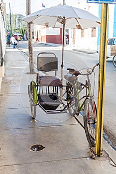 HOLGUIN, CUBA - JAN 28, 2016: Bici taxi on the street in Holguin, Cu photo