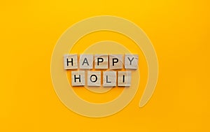 Holi is a celebration of spring and bright colors in India, a minimalistic banner with an inscription in wooden