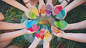 Holi paints in the hands of girls. Hands in a circle.