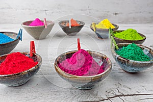 Holi powder in cups arranged in circle with pegs