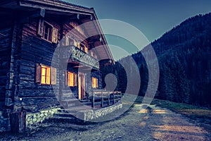 Holiday in the alps: Rustic wooden farm hut in the night