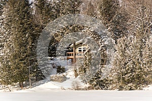 Holiday apartment in winter - wooden cottage in forest on the lake in Quebec