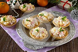 Holiday appetizer: tartlets with crab sticks, cheese and pineapple on Christmas or New Year holiday table