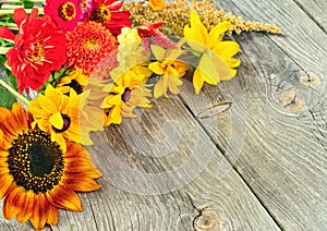 Holiday autumn bouquet. Frame of colorful flowers arranged on old wooden background.