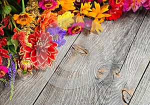 Holiday autumn bouquet. Frame of colorful flowers arranged on old wooden background.