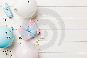 Holiday background with colorful balloon, gift and confetti. Flat lay style. Birthday or party greeting card with copy