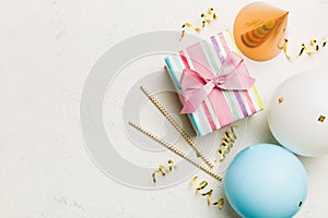 Holiday background with colorful balloon, gift and confetti. Flat lay style. Birthday or party greeting card with copy
