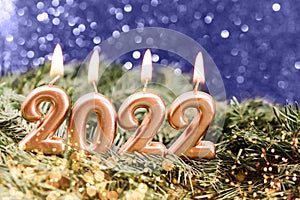 Holiday background Happy New Year 2021. Digits of year 2021 made by burning gold candles on red festive sparkling