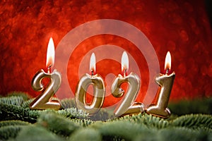 Holiday background Happy New Year 2021. Digits of year 2021 made by burning gold candles on red festive sparkling background