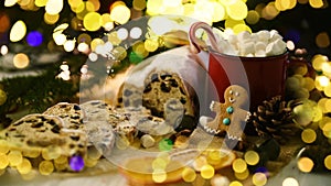 Holiday background Happy New Year 2024. cup and ginger man cookie on bokeh festive sparkling background.