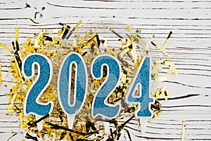 Holiday background Happy New Year 2024. Numbers of year 2024 made by blue candles on festive white wooden background