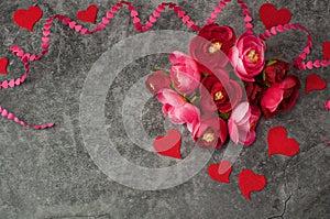 Holiday background for Valentine`s Day on a gray cement background with hearts, gifts and a ribbon