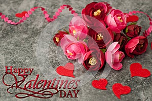 Holiday background for Valentine`s Day on a gray cement background with hearts, gifts and a ribbon