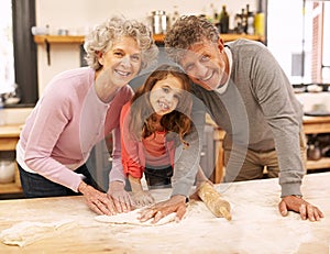 Holiday baking with Gran and Gramps. Portrait of a little girl and her grandparents baking together in the kitchen.