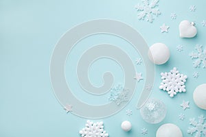 Holiday balls and decorative snowflakes on turquoise pastel background. Christmas or New year card. Minimalistic flat lay