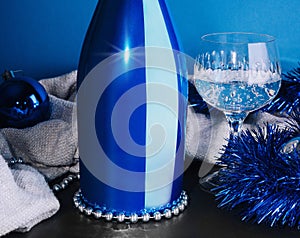Holiday Bottle of champagne and Christmas toys over blue background