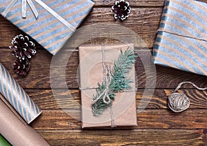Holiday boxes with beautiful bonnets and a Christmas tree branch on a wooden table
