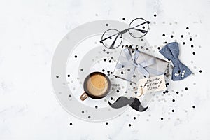 Holiday breakfast on Happy Fathers Day with cup of coffee, gift box, glasses, bowtie and moustache top view. Flat lay