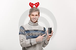 Holiday and Business Concept - Young handsome man showing mobile phone display and pointing finger presenting.