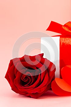 Holiday card close up red rose, box with gift and paper hearts. Valentine background. Happy Mother's day. Happy