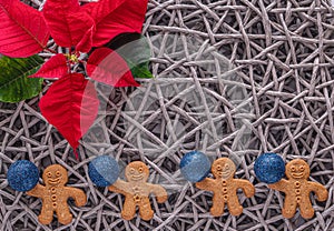 Holiday card - red flower poinsettia, fir cone, Christmas decorations on wicker straw gray background. Flat lay, top view, copy