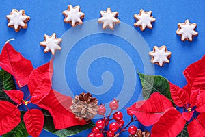 Holiday card - red flower poinsettia, stars on blue background. Christmas decorations, flat lay, top view