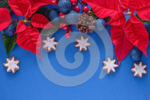 Holiday card - red flower poinsettia, stars on blue background. Christmas decorations, flat lay, top view