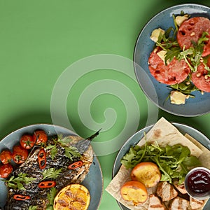 Holiday celebration table setting with food. Flat-lay of sweet cheesecake, fruit salad, meat dishes. Copy space banner.