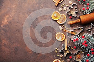 Holiday christmas background for baking cookies with cutters, rolling pin and spices on brown table top view. Copy space for text.