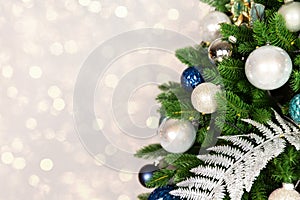 Holiday Christmas tree with ornaments and balls on golden background with bokeh lights