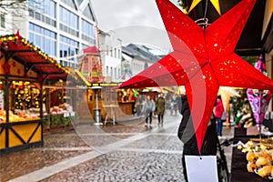 Holiday cityscape - view of star in the form of decoration on background of the Christmas Market