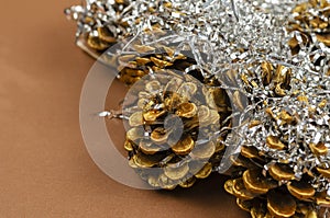 Holiday composition with Christmas decorations. Gold pine chicas, silver tinsel on brown background. Merry Christmas, happy new photo