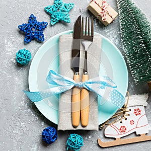 Holiday composition of Christmas dinner on cement background. Top view of plate, utensil and festive decorations. New Year Advent