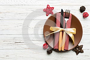 Holiday composition of Christmas dinner on wooden background. Top view of plate, utensil and festive decorations. New Year Advent