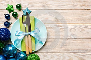 Holiday composition of Christmas dinner on wooden background. Top view of plate, utensil and festive decorations. New Year Advent