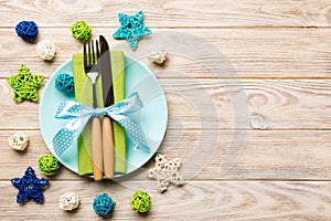 Holiday composition of Christmas dinner on wooden background. Top view of plate, utensil and festive decorations. New Year Advent