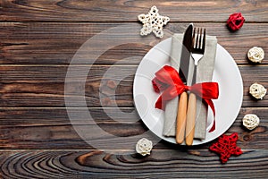 Holiday composition of Christmas dinner on wooden background. Top view of plate, utensil and festive decorations. New Year Advent