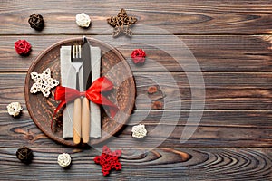 Holiday composition of Christmas dinner on wooden background. Top view of plate, utensil and festive decorations. New Year Advent