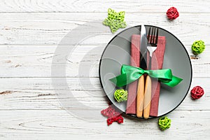 Holiday composition of Christmas dinner on wooden background. Top view of plate, utensil and festive decorations. New Year Advent