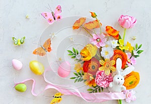 Holiday concept with bouquet of spring flowers, Easter eggs, bunny and butterfly on pastel vintage background. Easter composition