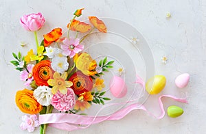 Holiday concept with bouquet of spring flowers Easter eggs and butterfly on pastel vintage background. Easter composition