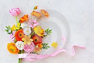 Holiday concept with bouquet of spring flowers on pastel vintage background. Easter composition