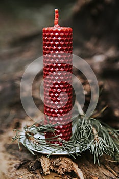 holiday concept candle on an old log in the forest