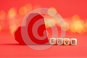 Holiday concept. Red paper handmade heart with word love on red background