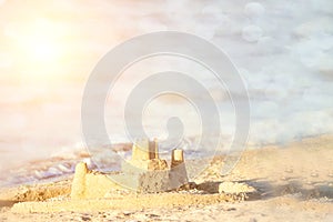 Holiday concept with sandcastle on the seaside. Summer background with copy space