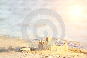 Holiday concept with sandcastle on the seaside. Summer background with copy space