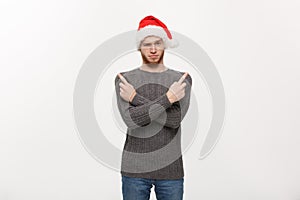 Holiday Concept - Young beard man in sweater enjoy playing and pointing finger onside with copyspace.