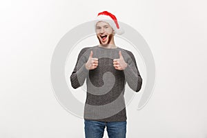 Holiday Concept - Young beard man in sweater giving thumb up to camera.