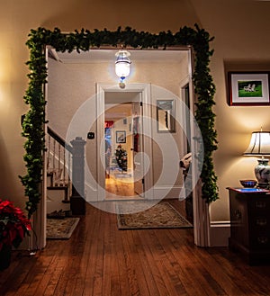 Holiday decorated archway as entrance to staircase and door to kitchen
